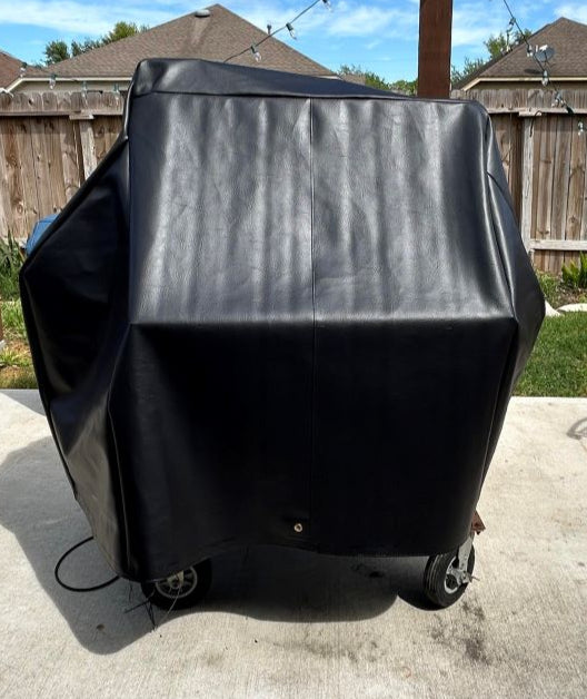 Black grill cover on a grill outdoors